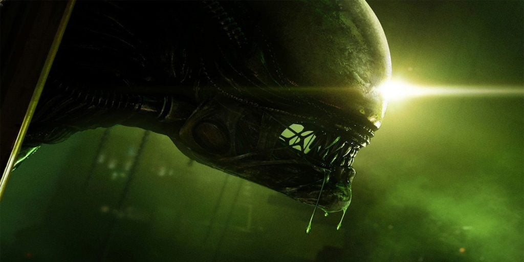 Promotional image for the video game Alien Isolation. The picture is a close up side-profile shot of an Alien from the game, with green light filling the frame.
