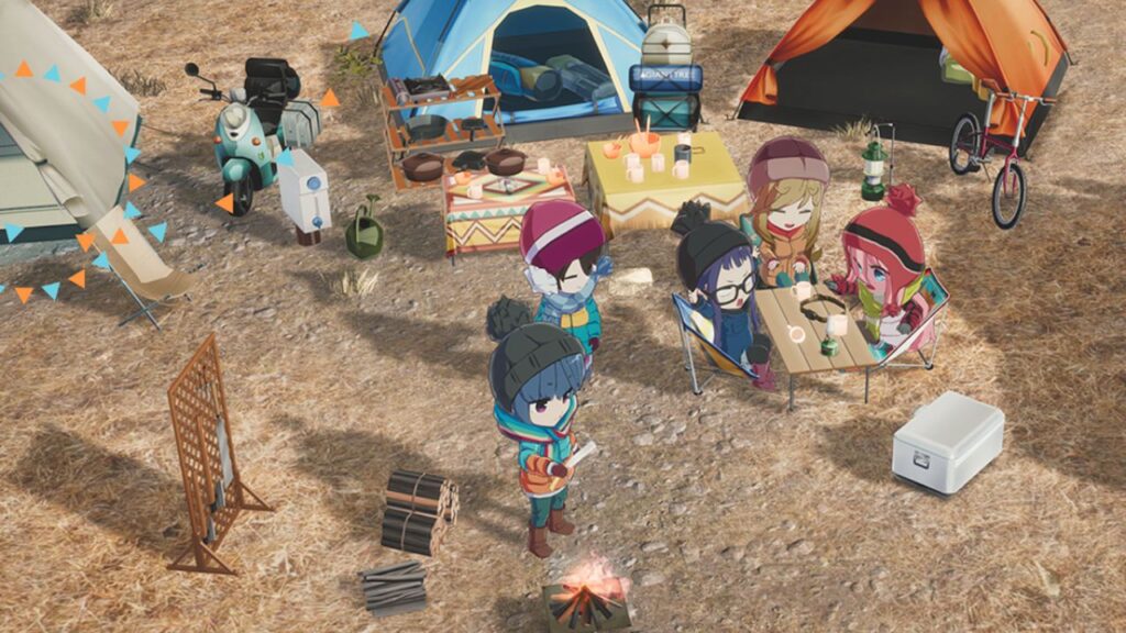 Feature image for our Laid-Back Camp: All-In-One news piece. It shows several characters stood round a camp fire in a circle of tents and chairs on pebble ground.