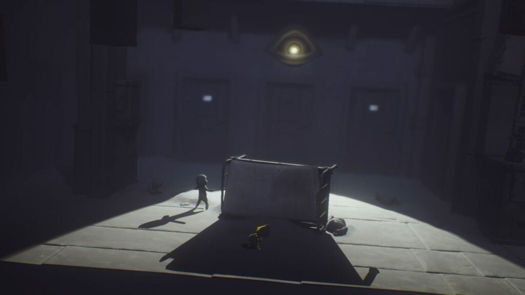 Feature image for our Little Nightmares Android release. It shows an in-game screen of a character in a yellow coat hiding behind an upturned bed from a looming eye, surrounded by petrified figures.