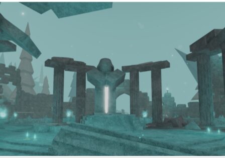the image shows the quincy statue which is shroud in a blue overcast. The stone structure is holding a glowing sword downwards into the earth below. Behind it is various columns of stone pillars and trees